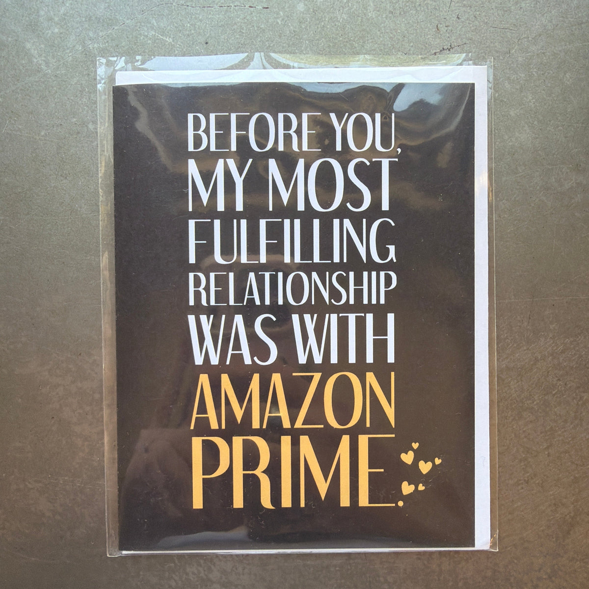 Funny black and white card with gold text humorously stating a fulfilling relationship with Amazon Prime, perfect as a gift or decor element from Knotty and Board, Fulfilled by Amazon Prime Funny Card.