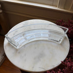 Clear glass Curved Appetizer Dish, Clear, Single, displayed on a marble table with decorative accents, perfect for stylish kitchen or dining entertaining by Knotty and Board. 1