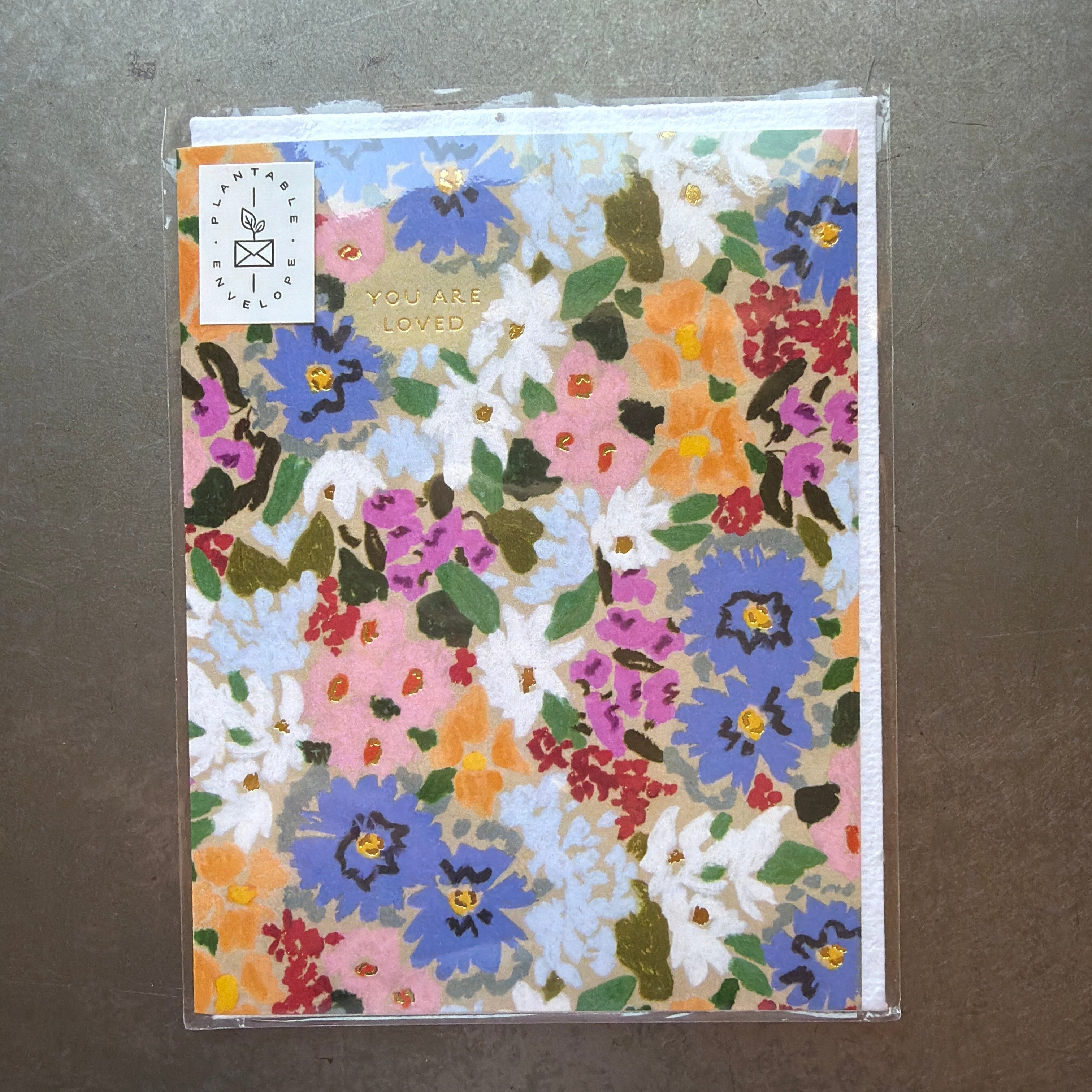 Seedlings Cards, Flourish, Love & Friendship featuring a vibrant floral design with colorful flowers in blue, pink, orange, and white, perfect for thoughtful gifts and decor from Knotty and Board.
