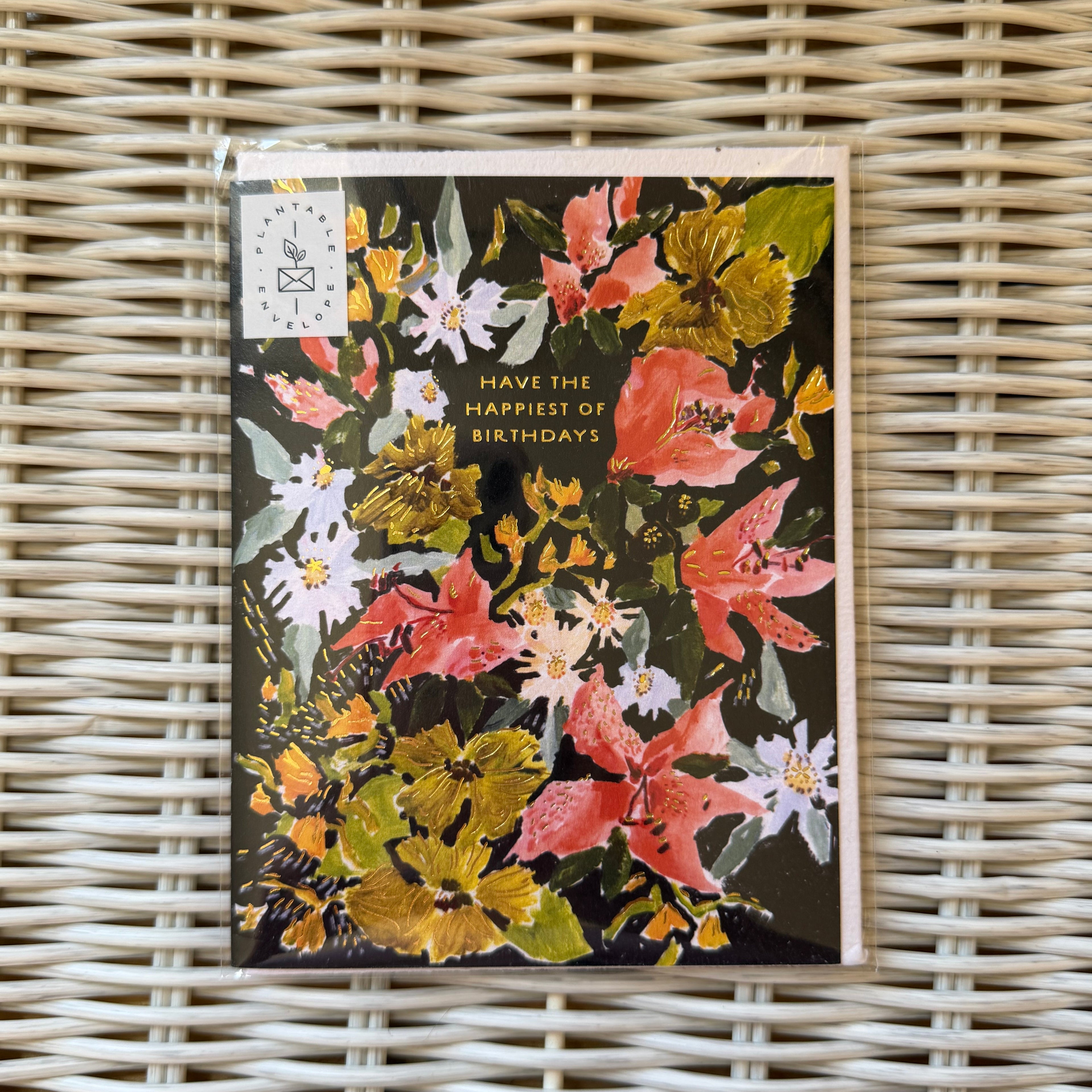 Seedlings Cards, Vintage Floral Birthday card with colorful hand-painted flowers and gold foil text that reads "Have the happiest of birthdays," displayed on a woven surface from Knotty and Board, perfect for gifts and decor.