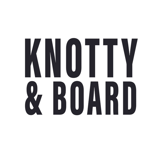 Bold black text on a white background spelling out Knotty and Board in a clean, modern font for a decor and gift brand logo.