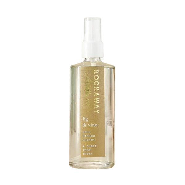 Clear spray bottle of Rockaway Fig & Vine Room Spray with gold label, promoting Knotty and Board’s curated decor and gifts, ideal for refreshing any room’s ambiance.