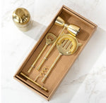 Gold Stick Bar Set 4 PC. displayed in a box on a marble surface, featuring a cocktail shaker, bottle opener, corkscrew, jigger, and strainer in polished gold finish, perfect for stylish entertaining. 1