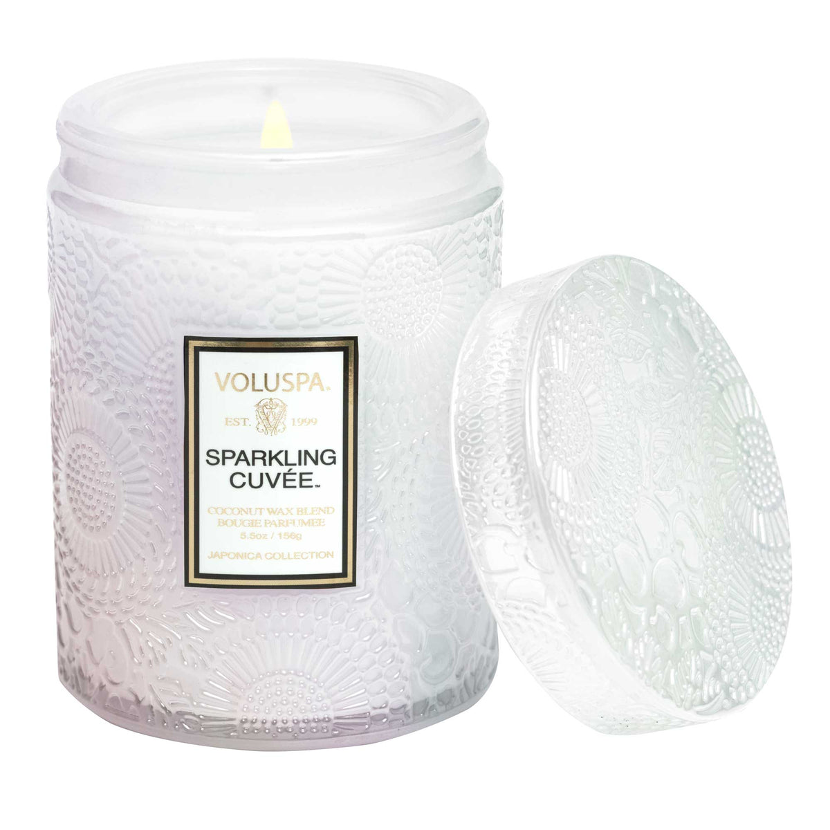 Voluspa Sparkling Cuvee Small Jar Candle, 5.5 oz burning in a textured white glass jar with the lid beside it, perfect for kitchen and dining decor or gifts from Knotty and Board.