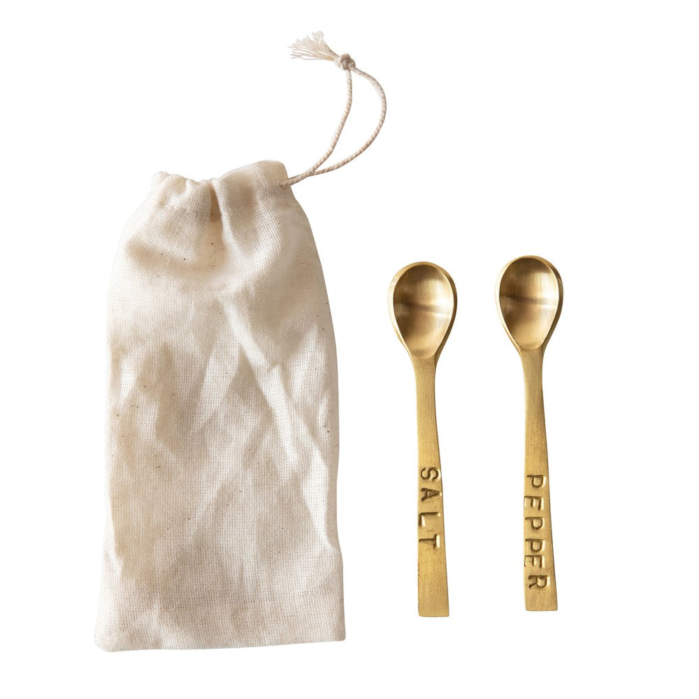 Salt & Pepper Spoons, Brass Finish displayed alongside a natural fabric drawstring pouch, perfect for kitchen decor and entertaining, offered by Knotty and Board with the tagline Every Room Needs A Little Knotty and Board.