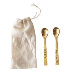 Salt & Pepper Spoons, Brass Finish displayed alongside a natural fabric drawstring pouch, perfect for kitchen decor and entertaining, offered by Knotty and Board with the tagline Every Room Needs A Little Knotty and Board. 3