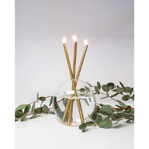 Three burning Everlasting Candles Gold, Candles Only, Set of 3 arranged in a clear round vase with green eucalyptus leaves, elegant decor for kitchen or dining by Knotty and Board.