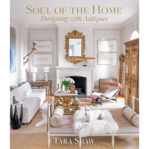 Elegant living room featuring classic antique decor with white furniture, a gold-framed mirror, ornate wooden cabinet, and soft accents, illustrating 