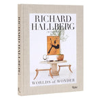 Hardcover book titled Hallberg Worlds of Wonder with a beige fabric cover featuring minimalist interior decor art on the front, ideal for Knotty and Board decor and gift collections. 1