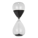 Clear glass hourglass with black sand measuring 15 minutes, an elegant decor piece featured in the Ferdinand 15-minute Hourglass, Black, 7 in. collection, ideal for gifts and home accents. 1