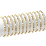 Multiple delicate gold beaded bracelets with small pearls displayed on a white stand, showcasing the Stretch Bead & Pearl Bracelet, 4mm, Gold, Priced individually, perfect for gifting and stylish jewelry decor. 1