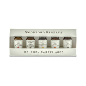 Bourbon Barrel Foods Woodford Bitters Dram Set featuring five small glass bottles of bourbon barrel aged bitters in a white branded box, perfect for kitchen or entertaining gifts.