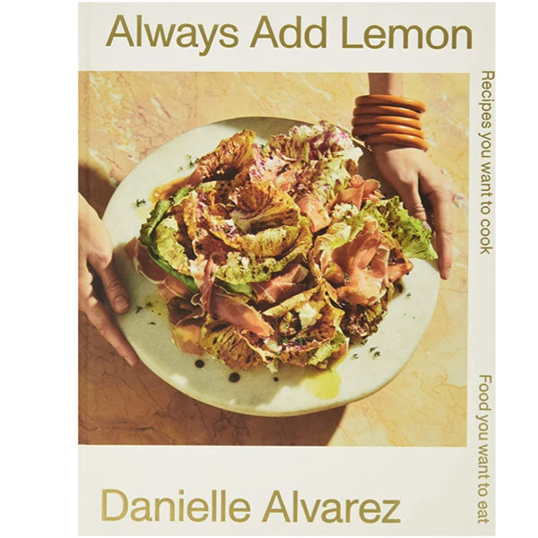 Cover of Always Add Lemon: Recipes You Want to Cook - Danielle Alvarez featuring a fresh salad with greens and cured meat on a ceramic plate, styled with kitchen decor and warm lighting from Knotty and Board.
