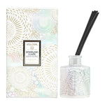Voluspa Sparkling Cuvee Reed Diffuser, 3.4 oz with an iridescent embossed glass bottle and black reeds, packaged in a decorative floral box, perfect for gift and home decor from Knotty and Board. 1