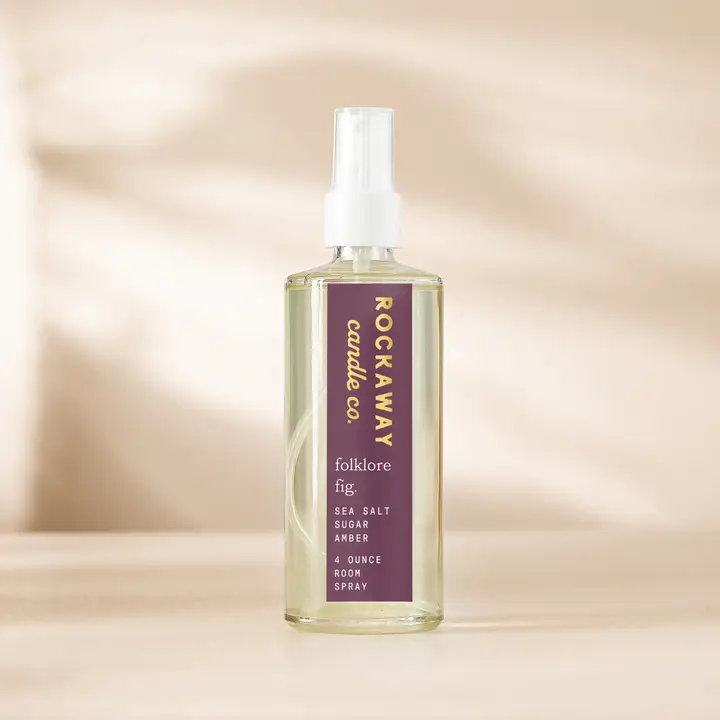 Clear glass spray bottle of Rockaway Folklore Fig Room Spray with purple label, displayed on a neutral background, perfect for decor and gifting at Knotty and Board.