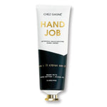 Tube of Hand Creme, Hand Job, Sea Salt Citrus and Neroli with gold and black packaging, emphasizing moisturizing formula made with cocoa butter and jojoba oil, featured by Knotty and Board for decor and gifts. 1