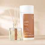 Rockaway Pale Fire Reed Diffuser with light amber scent liquid in a clear glass bottle and natural reed sticks, stylish brown and white packaging, decor gift idea. 1