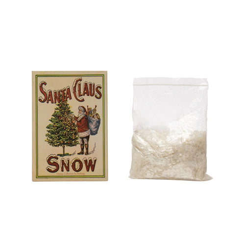 Santa Clause Snow" in Box, 7"H" featuring vintage-style holiday packaging with an illustration of Santa Claus and a Christmas tree, accompanied by a bag of artificial snow for festive decor.