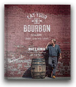 Cover of the Bourbon Barrel Foods Eat Your Bourbon Cookbook featuring a man leaning against a brick wall with a bourbon barrel, capturing a rustic kitchen and entertaining vibe from Knotty and Board. 1