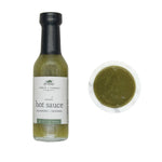 Bottle of Verde Hot Sauce, 5 oz with jalapeño and peppers flavor alongside a small dish of green hot sauce, perfect for kitchen or dining gifts from Knotty and Board. 1