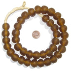 Close-up of brown Recycled Glass Beads 18 mm Assorted Colors arranged in a circle around a penny, highlighting handmade decor and jewelry elements from Knotty and Board.