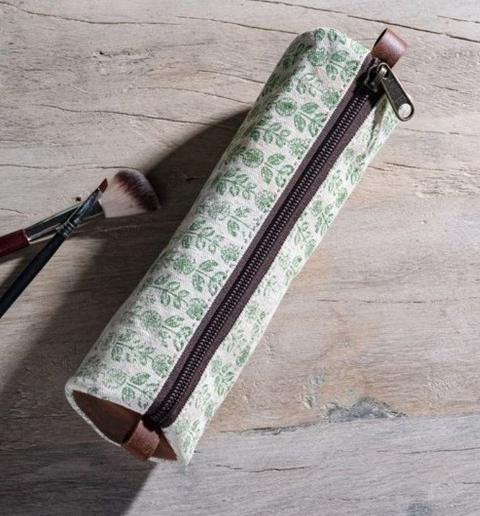 Green Floral Canvas Pencil Case 8.5" with a leafy pattern and brown zipper, displayed on a wooden surface alongside two makeup brushes, enhancing decor and gifting options.