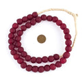 Deep Red Recycled Glass Beads, 14 mm, strung in a circular arrangement with a penny for size reference, perfect for jewelry making or unique decor by Knotty and Board.