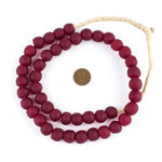 Deep Red Recycled Glass Beads, 14 mm, strung in a circular arrangement with a penny for size reference, perfect for jewelry making or unique decor by Knotty and Board. 1