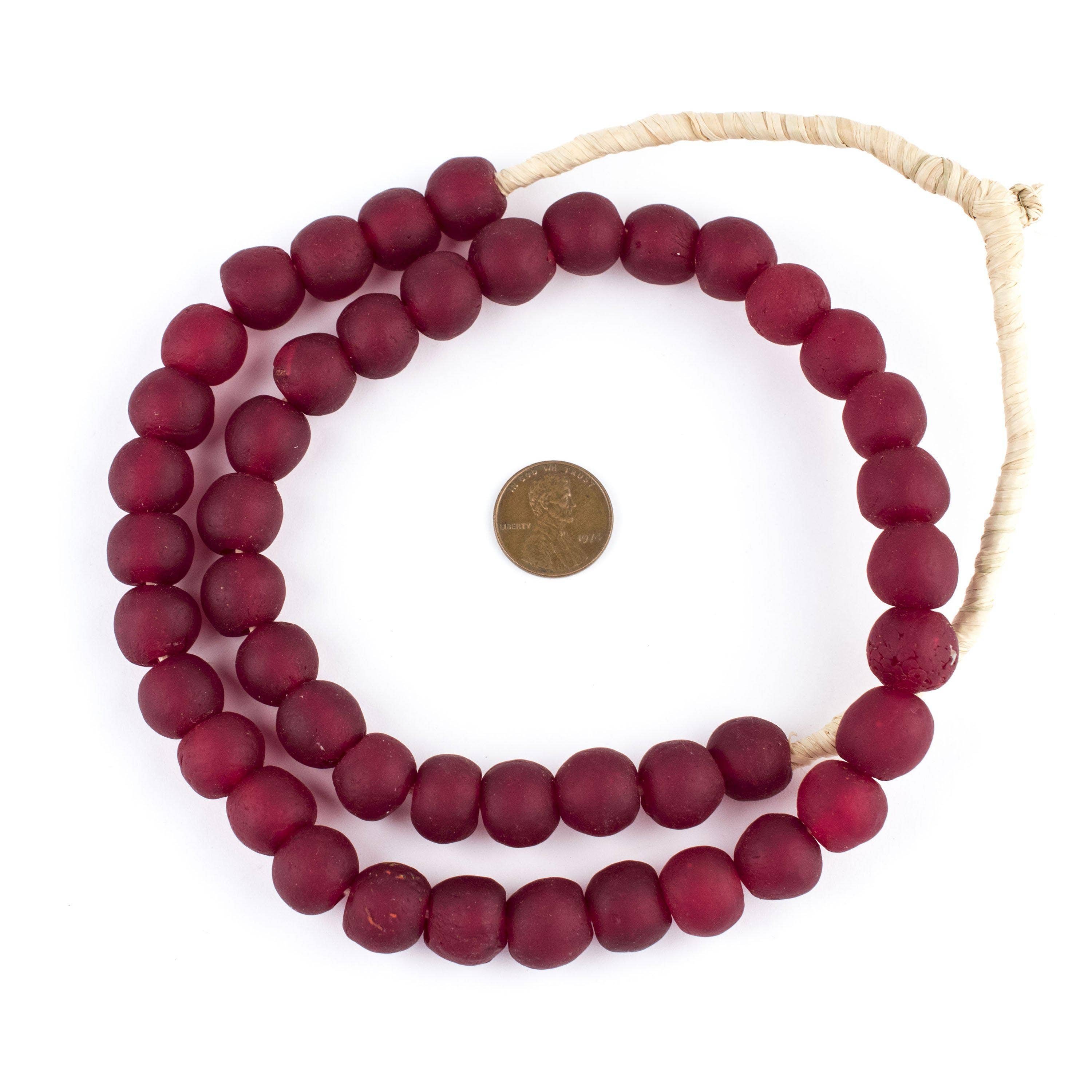 Deep Red Recycled Glass Beads, 14 mm, strung in a circular arrangement with a penny for size reference, perfect for jewelry making or unique decor by Knotty and Board.