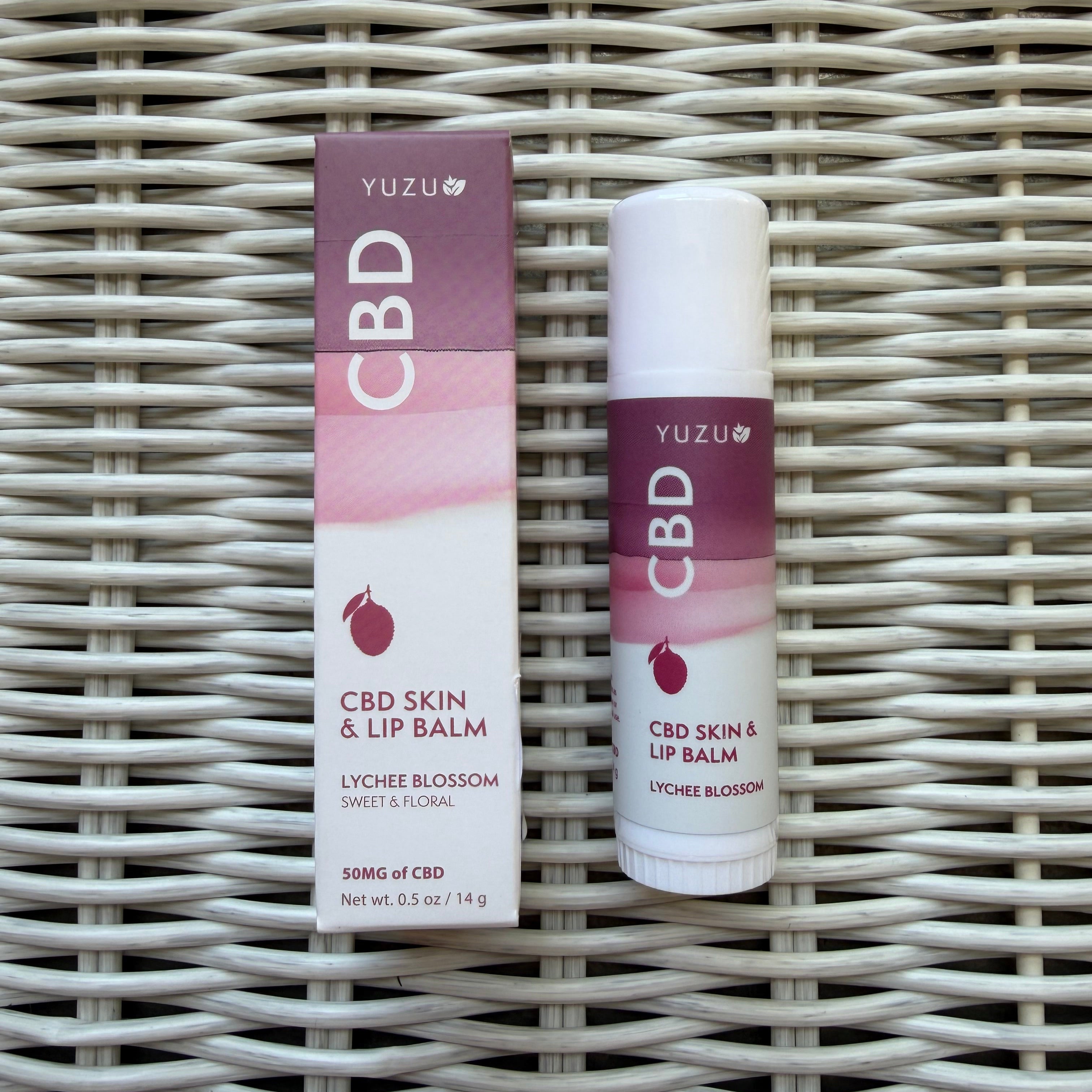 Yuzu Hemp Skin & Lip Balm, 50 mg, Lychee Blossom in white and purple packaging on woven surface, perfect for decor or gifts from Knotty and Board.