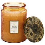 Voluspa Baltic Amber Candle Jar, Large, 18 oz. in an amber glass jar with intricate floral embossed design and matching decorative lid, perfect for home decor and gifts from Knotty and Board. 1