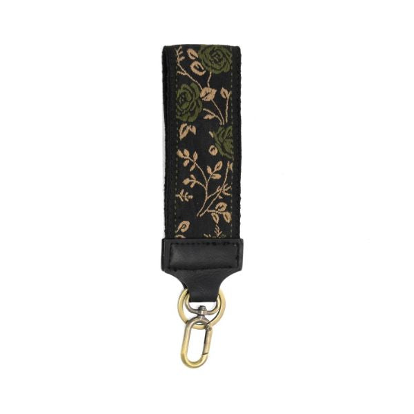 Easy Find Wristlet, Olive Untamed Roses featuring an olive and tan floral pattern on black fabric with leather detail and a gold clasp, perfect for stylishly organizing keys or small items.