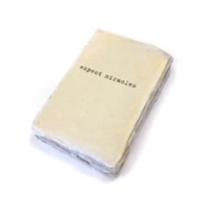 A cream-colored Deckled Edge Notebook - Expect Miracles with rough, textured edges and simple typewriter-style text on the cover, ideal for curated decor and gifts.
