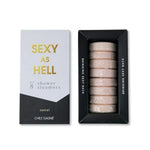 Boxed set of eight beige shower steamers labeled Shower Steamers, Sexy As Hell, Santal, presented in elegant packaging with gold and black lettering, offered by Knotty and Board for home decor and gifts. 1