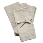 Slub Cotton Everyday Napkins, Set of Four, Sand, neatly folded with one tied in a bow, offering a soft textured look perfect for kitchen and dining decor from Knotty and Board. 1