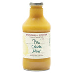 Stonewall Kitchen Pina Colada Mixer, 24 oz. in a clear bottle with a silver cap, featuring pineapple and coconut flavors, perfect for kitchen and entertaining gifts from Knotty and Board. 1