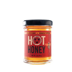 Savannah Bee Co., Hot Honey, 3 oz. jar with a red label featuring a bee design, perfect for kitchen gifts and entertaining from Knotty and Board. 1