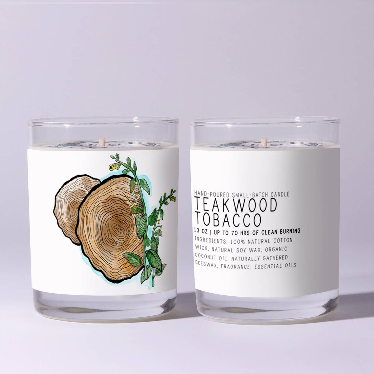 Two clear glass candles labeled Just Bee Teakwood Tobacco - 7 oz featuring wood grain and greenery illustration, perfect for rustic decor and gifts from Knotty and Board.