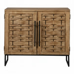 A two-door wooden cabinet with a woven rattan-style front design, dark metal handles, and black legs, shown against a plain white background. 2