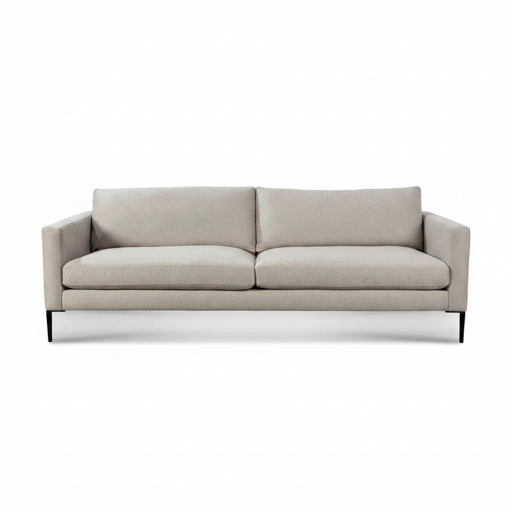 A modern two-seater sofa upholstered in a light beige textured fabric, featuring slim black metal legs, shown against a plain white background.