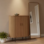 A mid-century modern bamboo cabinet with a curved front, vertical slatted bamboo doors, and thin black metal legs, shown against a plain white background. 2