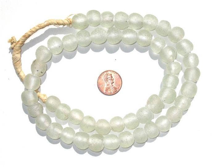 Clear Recycled Glass Beads, 14 mm, strung on natural twine next to a penny for size comparison, perfect for decor, jewelry making, and unique gifts from Knotty and Board.
