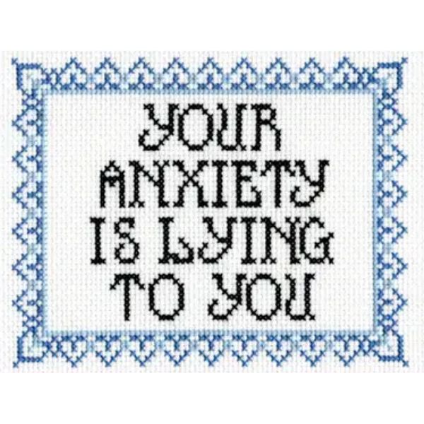 Cross stitched message "Your Anxiety Is Lying To You" framed with a decorative blue heart and triangle border from the Deluxe Cross Stitch Kit, Your Anxiety Is Lying To You, perfect for thoughtful home decor gifts.