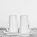 Minimalist white ceramic Salt and Pepper Shakers with Tray, White, placed on a textured surface, perfect for elegant kitchen decor and gift ideas from Knotty and Board.