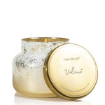 Capri Blue Glimmer Volcano Signature Jar Candle, 19 oz. featuring a shimmering gold jar and matching lid, perfect for adding cozy decor or a thoughtful gift from Knotty and Board. 1