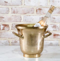 Elegant Gold Ice Bucket 7.5" with a textured gold finish holding a chilled bottle, perfect for entertaining and adding stylish decor from Knotty and Board.