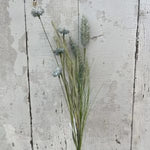 Wildflower Spray, 21 in. Blue arranged against a rustic, weathered white wooden background, perfect for adding natural decor charm to any room with Knotty and Board. 1